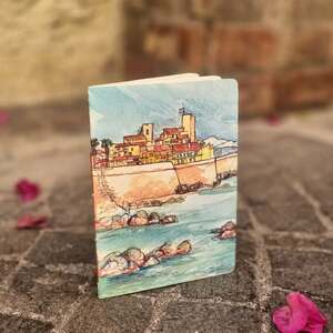 Un classique qui traverse le temps et qui trouve toujours quelqu’un à qui plaire. 💙
Cette illustration est l’une des toutes premières que j’ai dessinées après m’être installée à Antibes. Une vue qui m’apaise encore aujourd’hui, glissée sur la couverture d’un carnet souple, léger et pratique, à emporter partout.
Un petit morceau d’Antibes à garder près de soi. 🌊✨